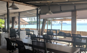 Coworking space directly at the sea. No windows just tables with chairs pointing at blue water and islands